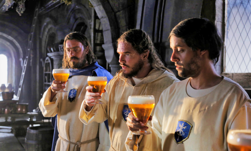 Drie Affligem paters met het abdijbier in de hand binnen in de abdij